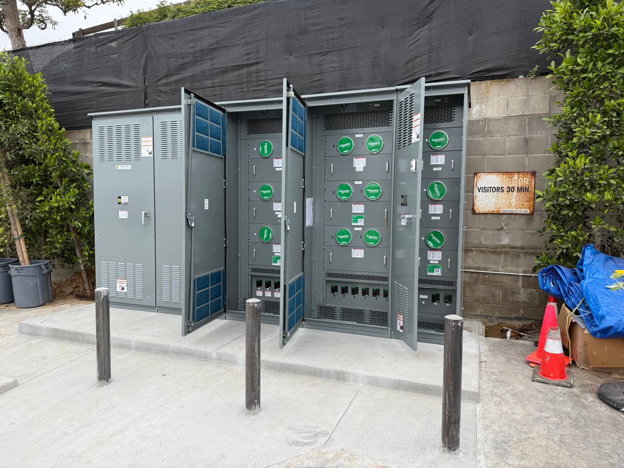 Outdoor electrical meter section with doors open to show the meter positions