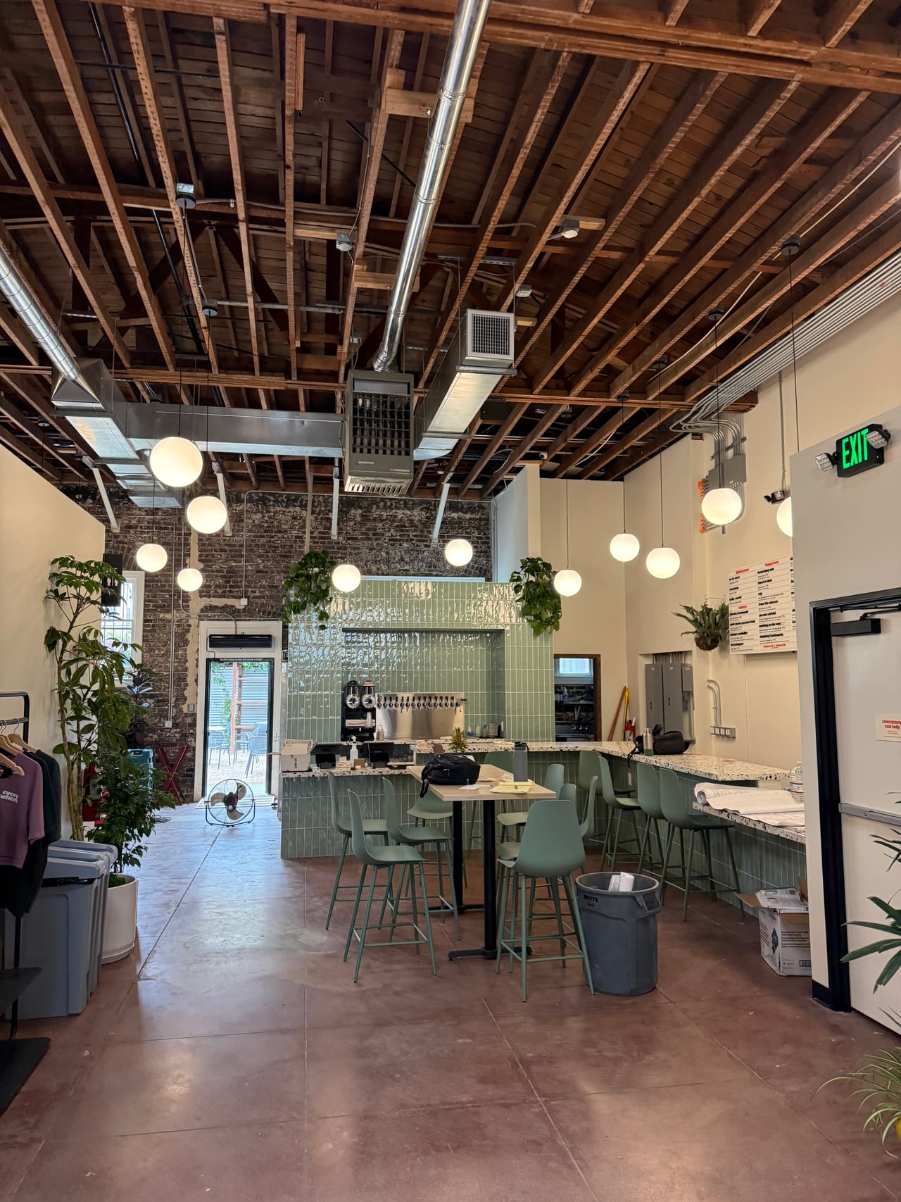 Interior with an exposed ceiling, electrical panels and conduit at Everywhere Brewing Co.