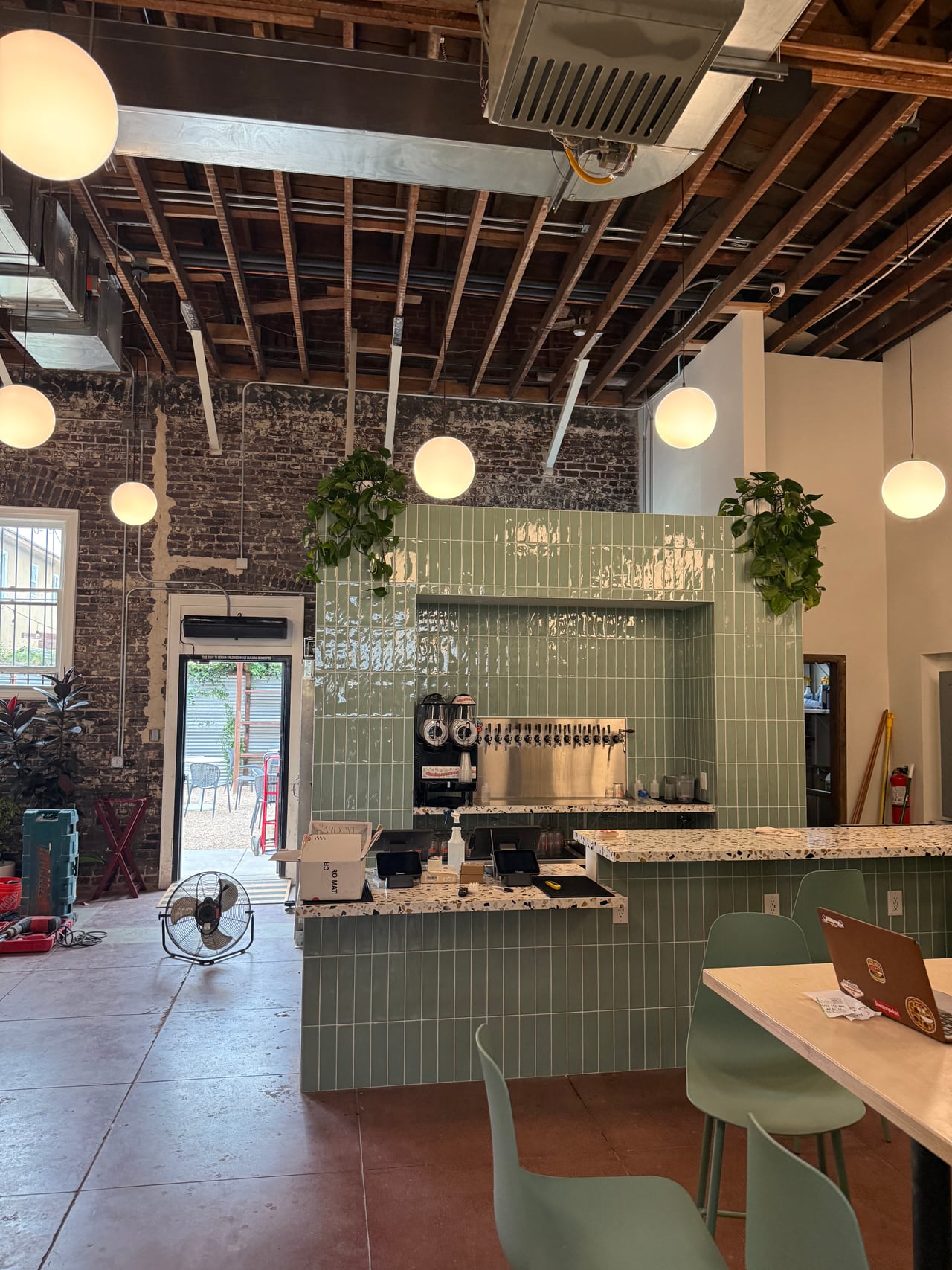 Globe pendant lights above the green bar at Everywhere Brewing Co. in Long Beach