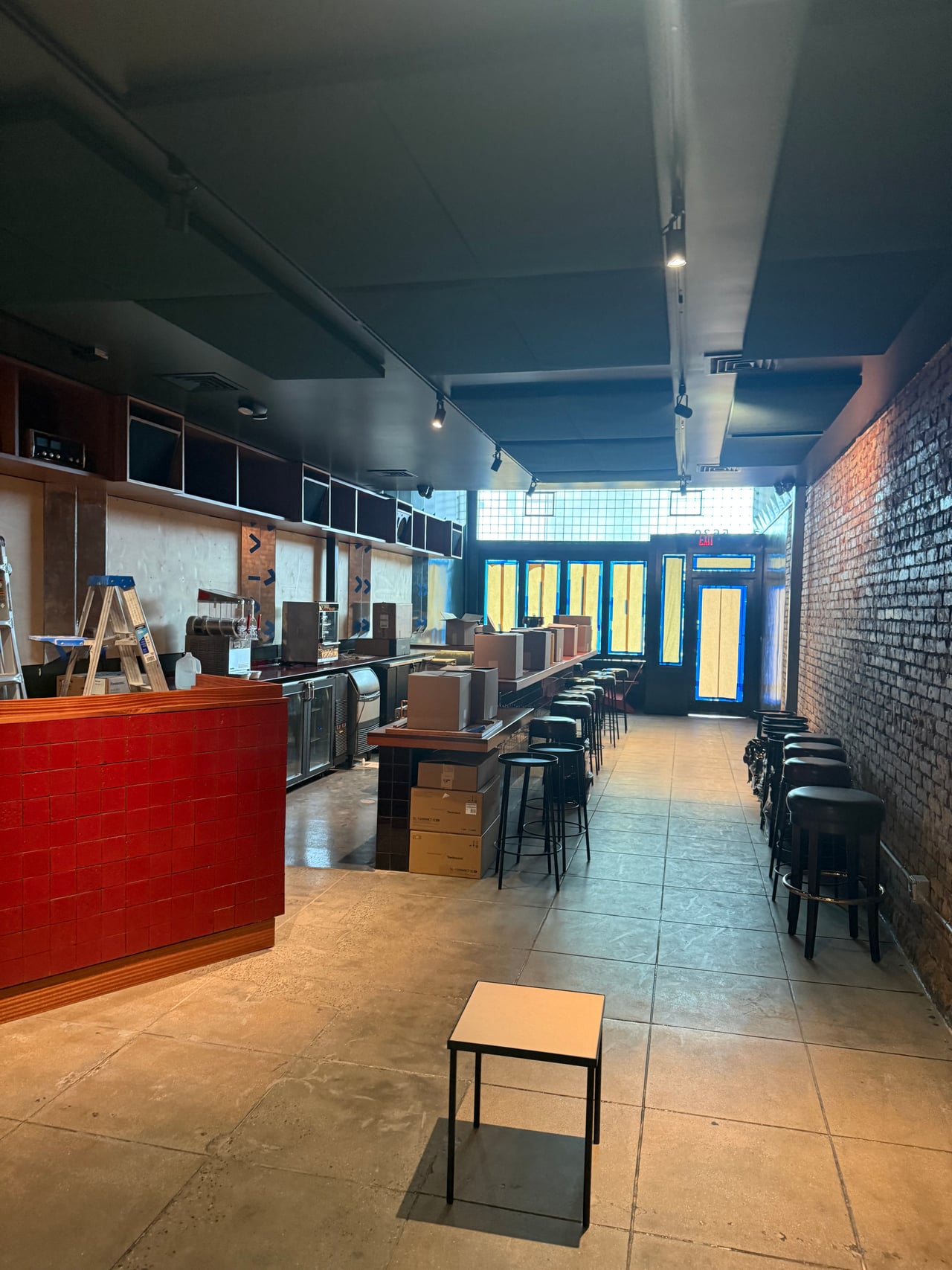 Track lighting above the bar and seating at Goldline Bar in Los Angeles