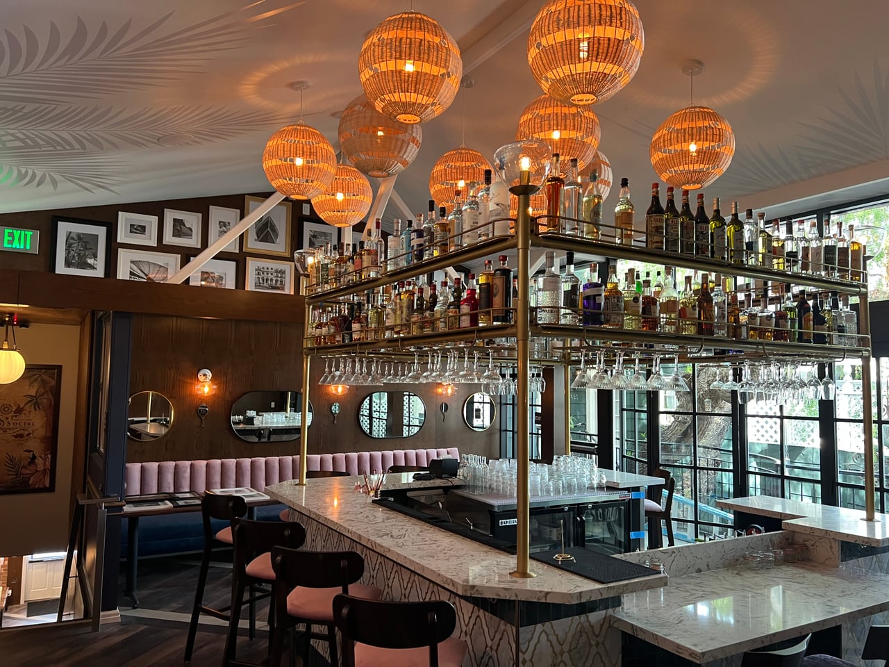 Warm pendant lighting above the marble bar at Rum Social in Laguna Beach