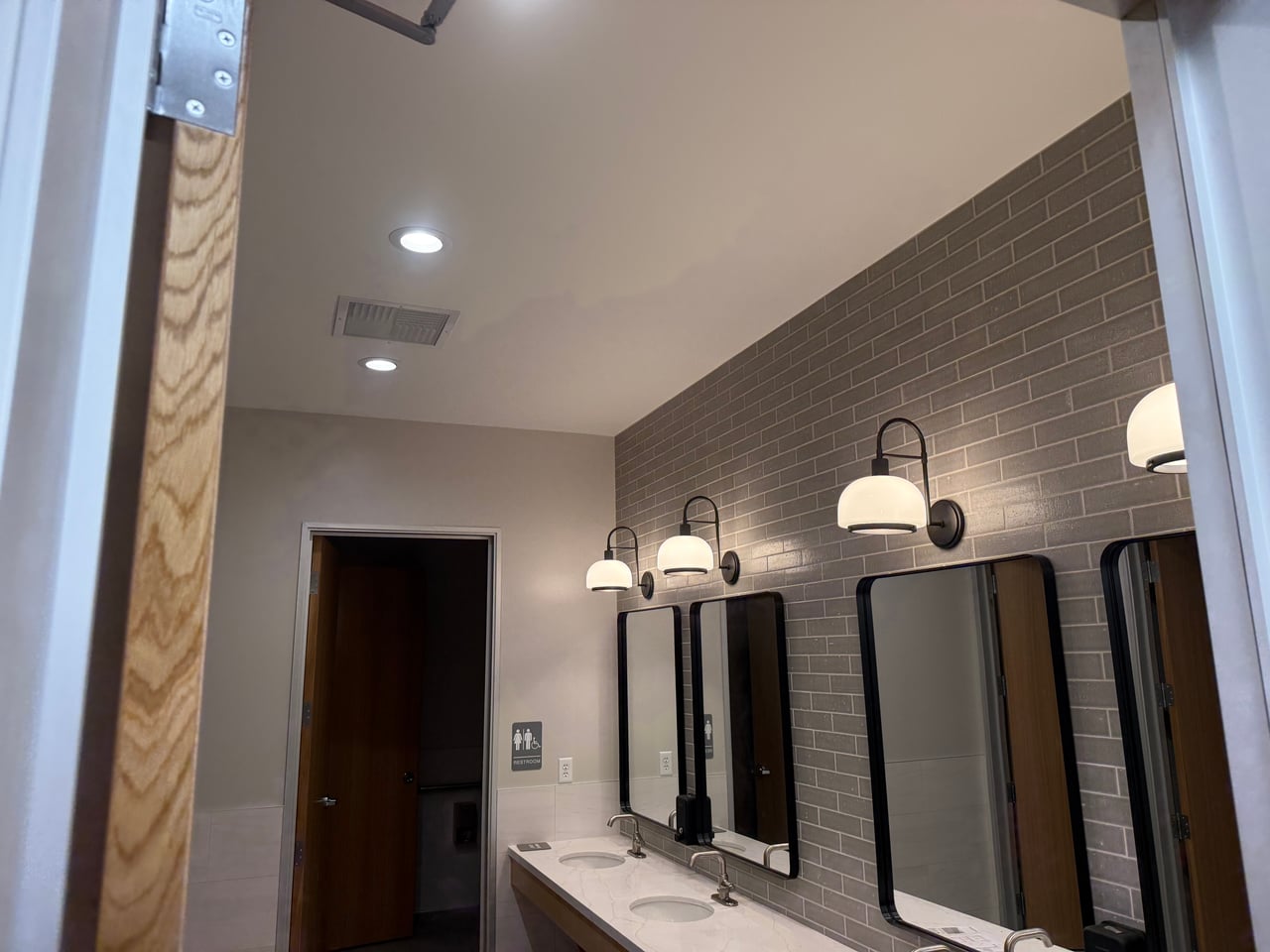 Wall sconces and recessed ceiling lights in the restroom at Highland Lumber