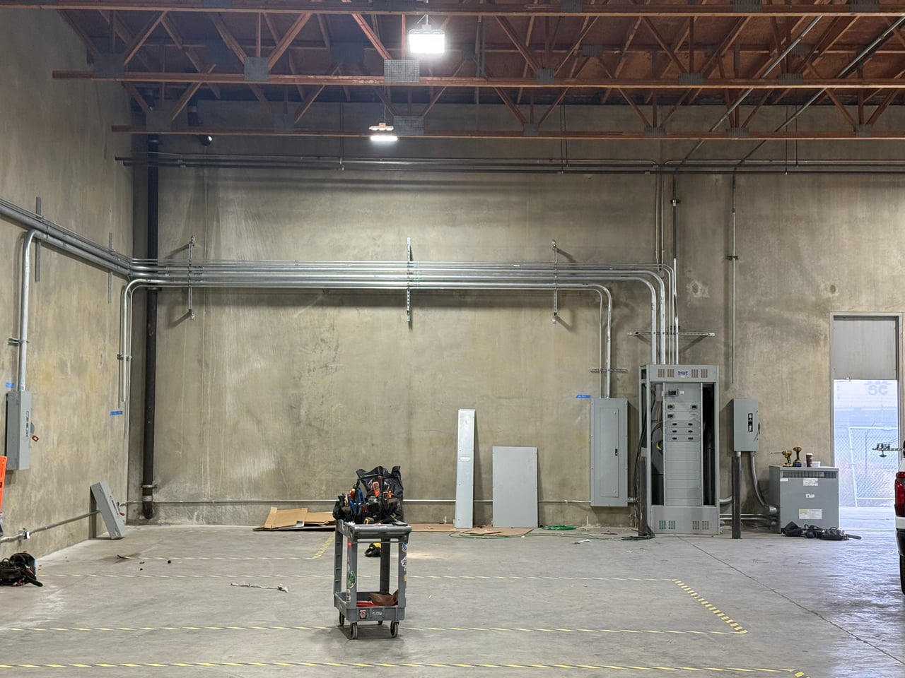 Electrical distribution equipment and conduit runs along a facility wall at Sunset Vans